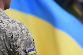 Ukrainian soldier in a uniform and Ukrainian flag